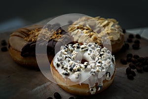Three doughnuts covered with Cookies and creme, Choco peanut butter and Almendras photo
