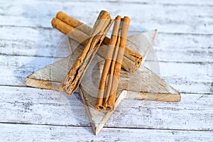 Three dre cinnamon sticks on wooden star