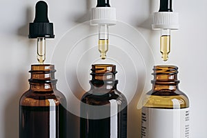 Three dropper bottles amber and clear on a white background