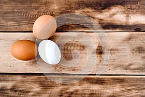 Three easter eggs on a wooden dark table.