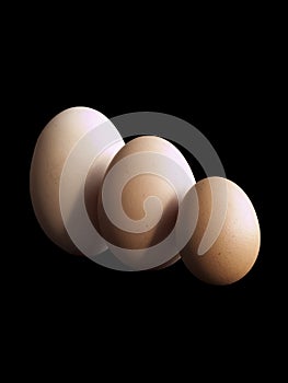 Three eggs on black background