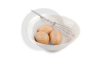 of Three Eggs in a Bowl and Whisk