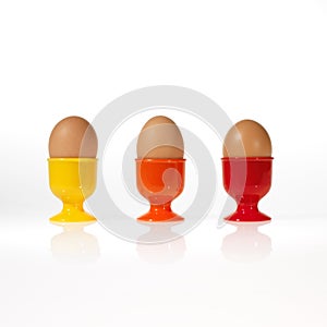 Three eggs in colorful egg cups