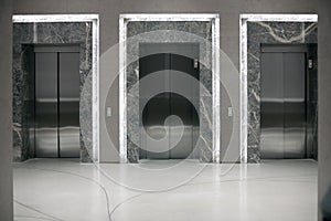Three elevator entrances in an empty interior photo