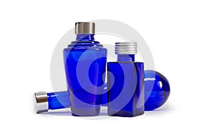 Three empty cobalt blue glass lotions and potions bottles.