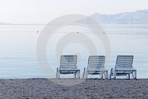 Three empty deck chair on the beach