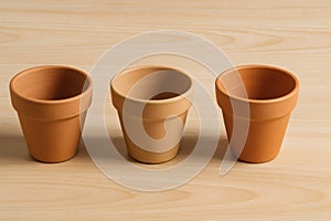 Three Empty Flower Pots on Light Wooden Surface