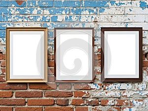 Three empty frames against a distressed brick wall