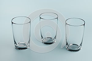 Three empty glass beakers on a blue background