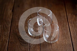 Three empty glasses on a brown wooden desk