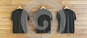 Three empty t-shirts hanging on woooden wall background. Ad, textile and fashion concept. 3D Rendering