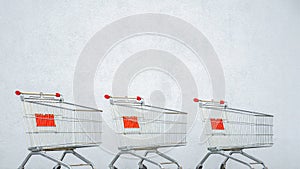 Three Empty Trolley at the Supermarket. Grocery Cart on the White Wall Store. Shopping Cart Trolley Stands near Mall