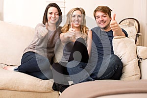 Three enthusiastic teenagers giving a thumbs up