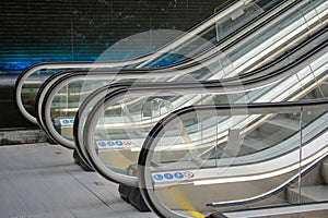 Three escalators (moving stairs) in a shopping mall.