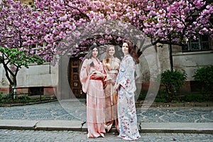Three european girls wearing traditional japanese kimono