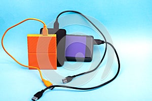 Three external portable hard disk drives isolated on light blue