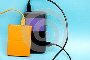 Three external portable hard disk drives isolated on light blue