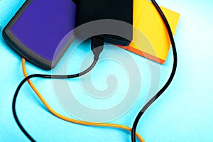 Three external portable hard disk drives isolated on light blue