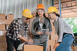 three factory employees deliberate while checking goods in the warehouse