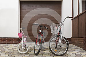 Three family bikes stand in front of the house.
