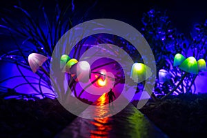 Three fantasy glowing mushrooms in mystery dark forest close-up. Beautiful macro shot of magic mushroom or three souls lost in