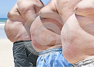 Three fat men on a beach photo