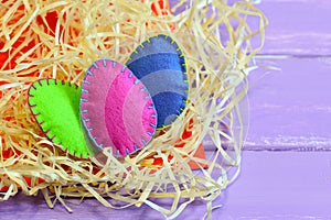 Three felt eggs of different colors. Easy and quick felt eggs decor. Elegant Easter composition. Easter table decoration