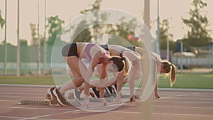 Three female athletes simultaneously start running marathon, rivalry, slow-motion. women standing on a starting line