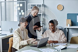 Three Female Coworkers Looking at Laptop Screen