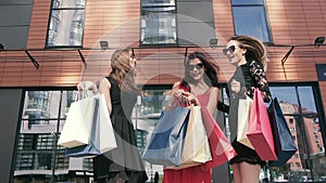 Three female friend meeting outdoors after shopping