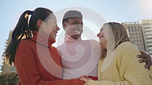 Three female friends affectionately hug each other having fun together laughing happy smiling.