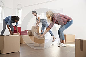 Three Female Friends Carrying Boxes Into New Home On Moving Day