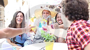 Three female friends drinking cocktails on terrace cafe in summer