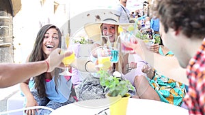 Three female friends drinking cocktails on terrace cafe in summer