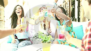 Three female friends drinking cocktails on terrace cafe in summer