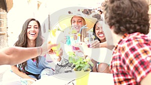 Three female friends drinking cocktails on terrace cafe in summer