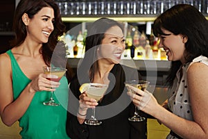 Three Female Friends Enjoying Drink In Cocktail Bar