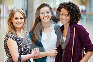 Three Female Friends Shopping In Mall Together