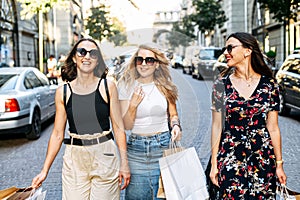 Three female friends walk after shopping
