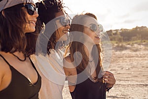 Three female friends walking on the beach