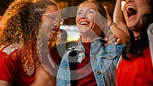 Three Female Friends Watching a Live Soccer Match on TV in a Sports Bar. Happy Girls Cheering and