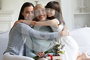 Three female generations celebrating International Womens Day looking at camera