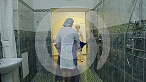 Three female nurses deliver a sedentary patient to a specialized room in order to wash it