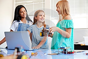 Three Female Students Building And Programing Robot Vehicle In After School Computer Coding Class