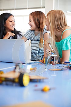 Three Female Students Building And Programing Robot Vehicle In After School Computer Coding Class