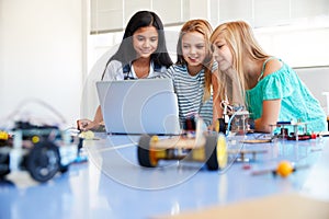 Three Female Students Building And Programing Robot Vehicle In After School Computer Coding Class