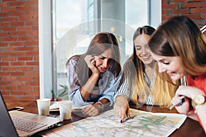 Three female students doing geography homework together at home