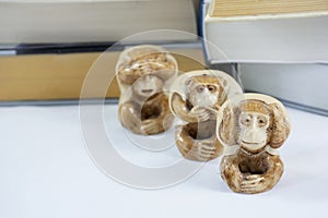 Three figurines of monkey with many books
