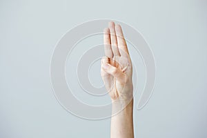 Three finger salute on grey background