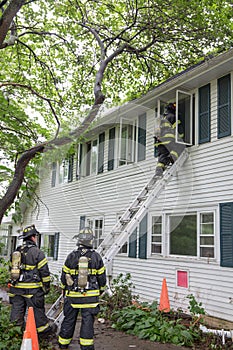 Three Firefighters on Fire Scene in front of a building